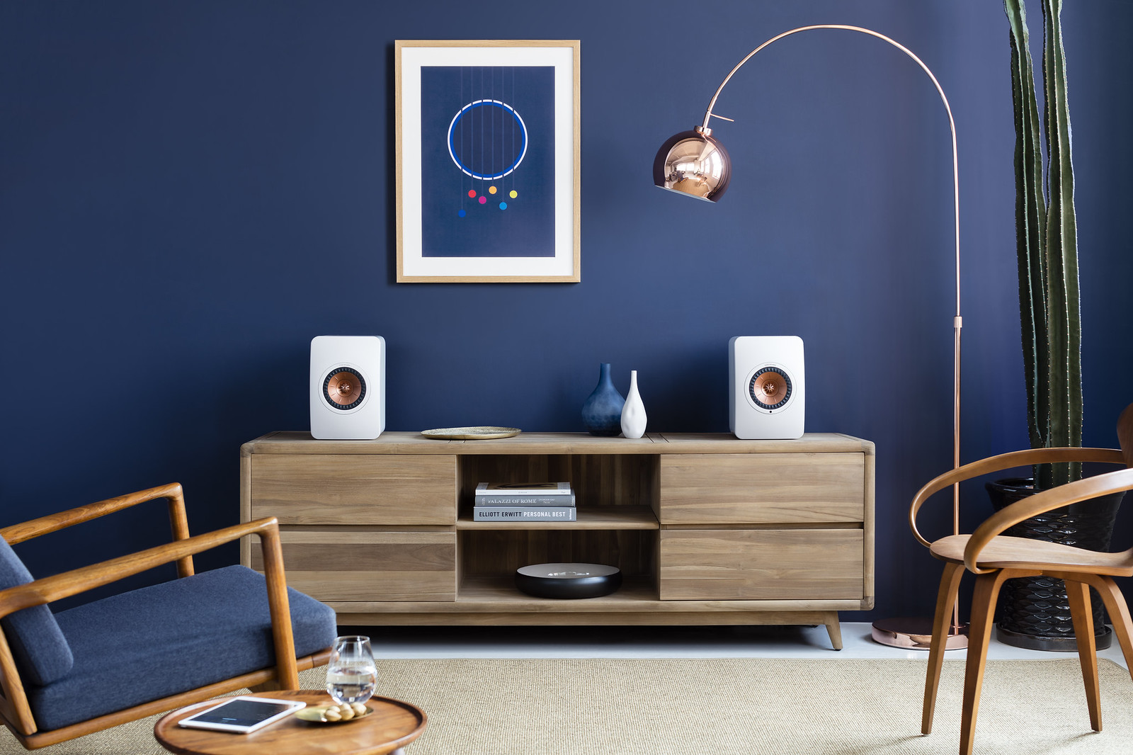 Explora el Sonido Superior de la Serie Ci de KEF en el Techo Hoy 1 Sala de estar moderna con altavoces KEF en un gabinete de madera, perfecta para un artículo sobre experiencias de sonido superiores.