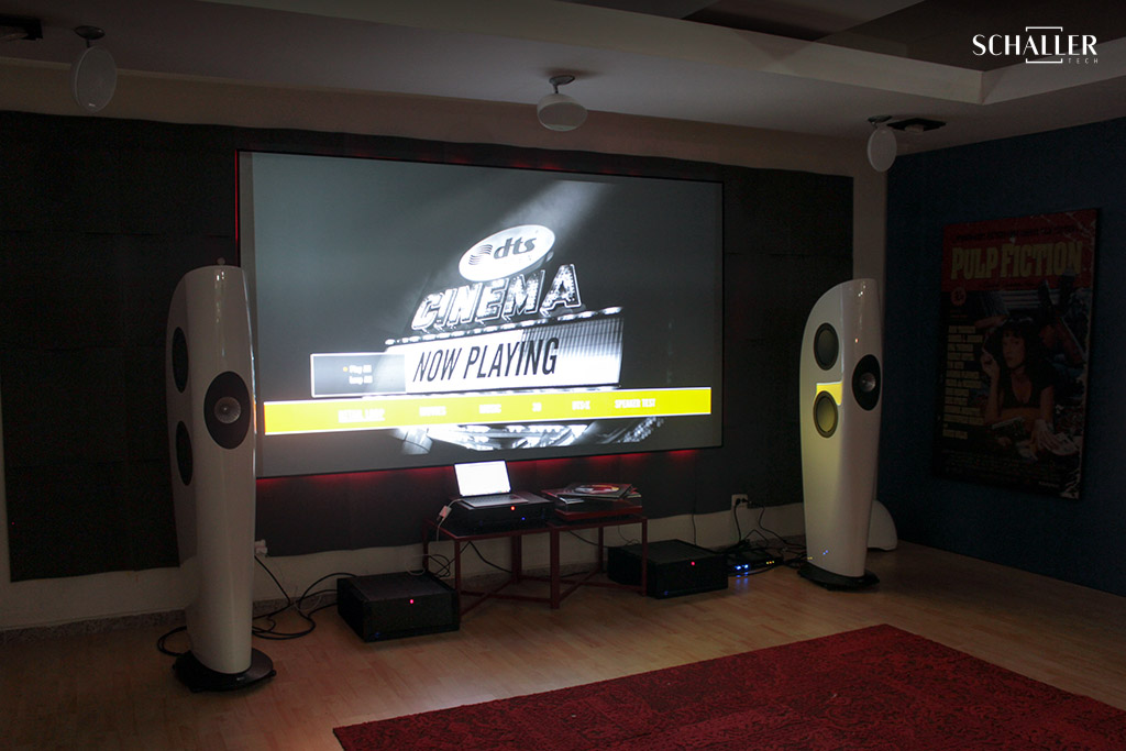 A modern AV integration design featuring a large screen displaying ‘DTS CINEMA NOW PLAYING’, flanked by two uniquely designed white speakers, in a cozy home theater setting, illustrating advanced audio-visual technology for the article ‘Exploring AV Integration Design: Definition, Scope, and Sector Impact’. Un diseño moderno de integración AV que presenta una gran pantalla que muestra ‘DTS CINEMA NOW PLAYING’, flanqueada por dos altavoces blancos de diseño único, en un acogedor entorno de cine en casa, ilustrando la tecnología audiovisual avanzada para el artículo ‘Explorando el Diseño de Integración AV: Definición, Alcance e Impacto Sectorial’.
