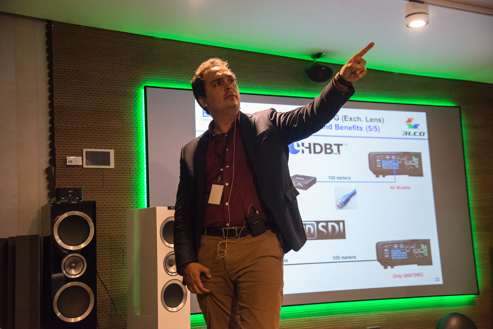 Mastering Audiovisual Design for Memorable Events and Shows 3 A presenter pointing towards a projection screen displaying technical information, symbolizing the importance of audiovisual design in creating engaging presentations for events and shows. Un presentador señalando hacia una pantalla de proyección que muestra información técnica, simbolizando la importancia del diseño audiovisual en la creación de presentaciones atractivas para eventos y espectáculos.