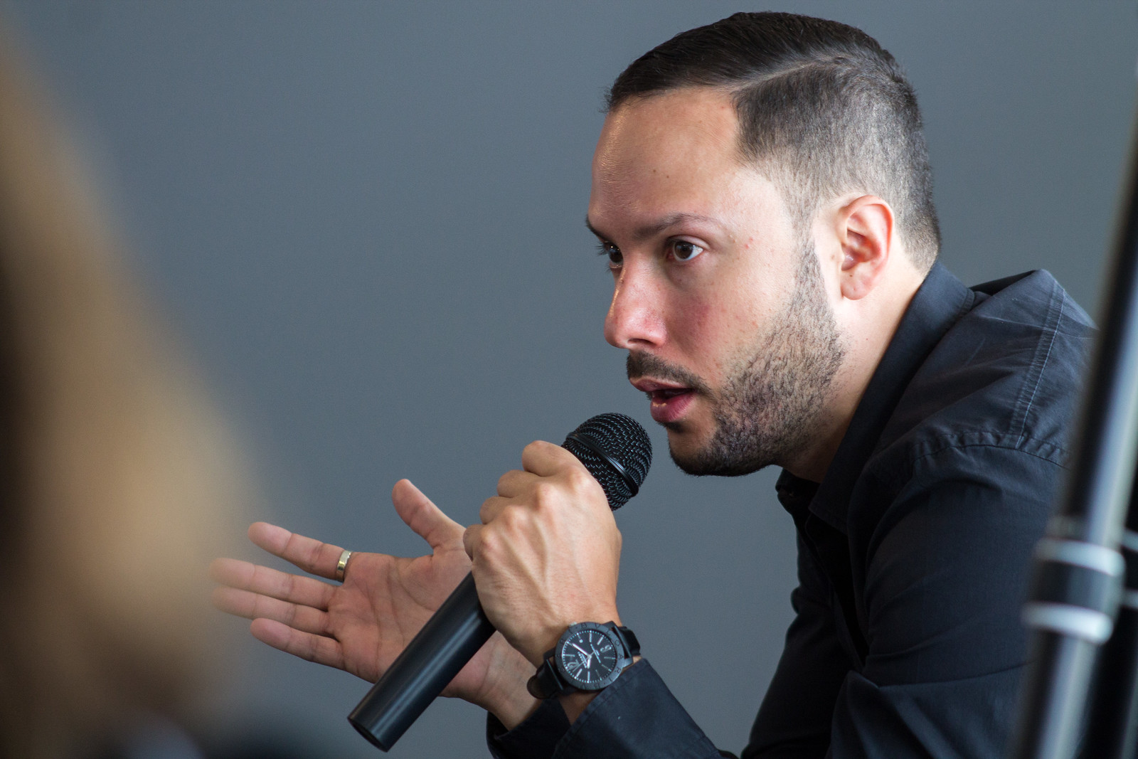 A person engaged in an interview, illustrating the use of a dynamic microphone, optimized for SEO for the article ‘Understanding Microphone Types and Key Sound Characteristics’. Una persona participando en una entrevista, ilustrando el uso de un micrófono dinámico, optimizado para SEO para el artículo ‘Entendiendo los Tipos de Micrófonos y Características Clave del Sonido’.