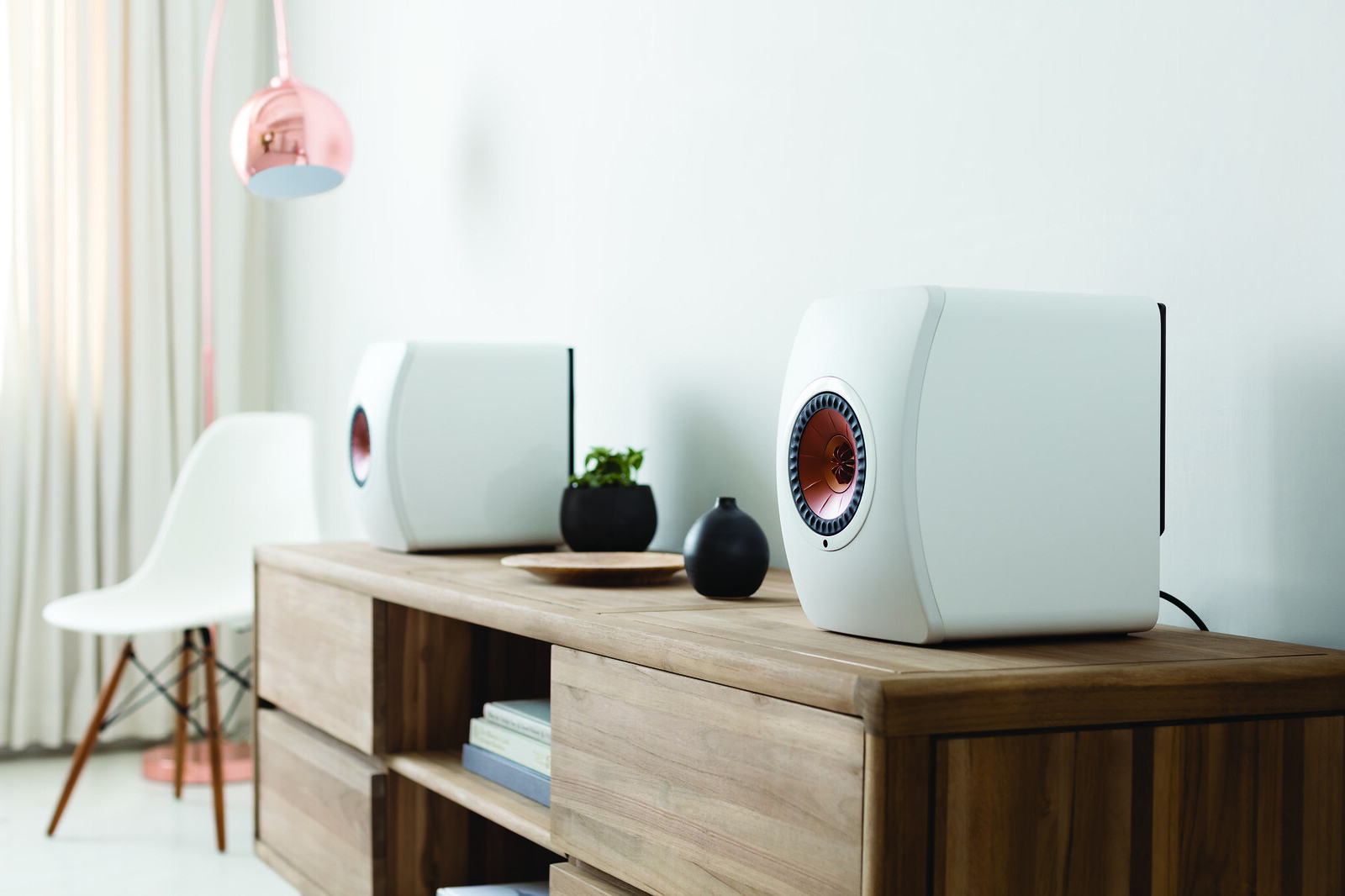 Deep Bass Secrets: Maximize Your Subwoofer Performance 5 Modern, minimalist living room with white speakers on a wooden console table, perfect for an article on ‘Deep Bass Secrets: Maximize Your Subwoofer Performance’. Sala de estar moderna y minimalista con altavoces blancos en una mesa de consola de madera, perfecta para un artículo sobre ‘Secretos de Bajos Profundos: Maximiza el Rendimiento de Tu Subwoofer’.