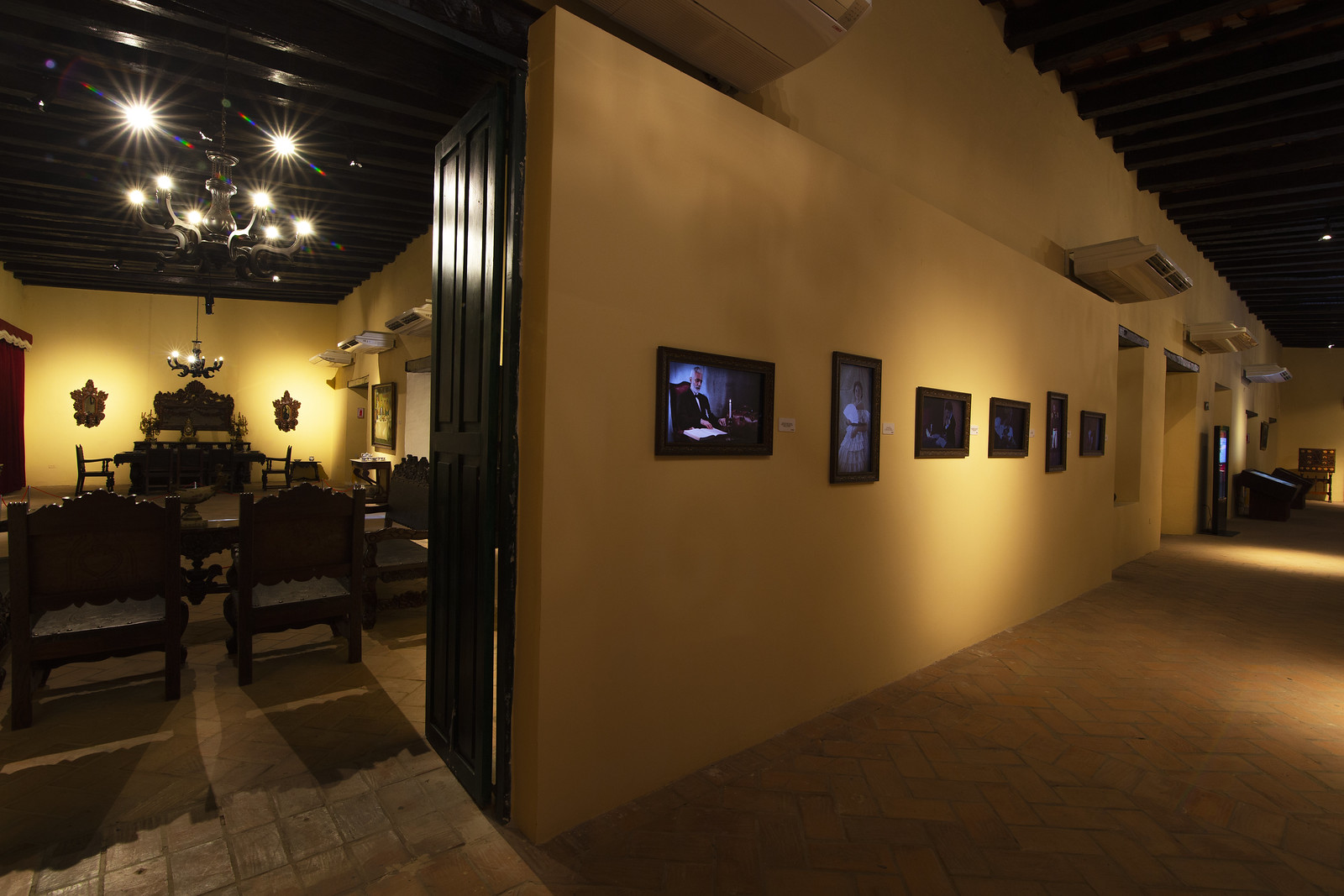 The Healing Harmony: Social and Cultural Impacts of Performing Arts Centers 1 An art gallery with a rustic charm, featuring a yellow wall adorned with various framed artworks, and an adjacent room visible through an open door, symbolizing the diverse cultural influences explored in ‘The Healing Harmony: Social and Cultural Impacts of Performing Arts Centers’. Una galería de arte con un encanto rústico, que presenta una pared amarilla adornada con varias obras de arte enmarcadas, y una habitación adyacente visible a través de una puerta abierta, simbolizando las diversas influencias culturales exploradas en ‘The Healing Harmony: Social and Cultural Impacts of Performing Arts Centers’.