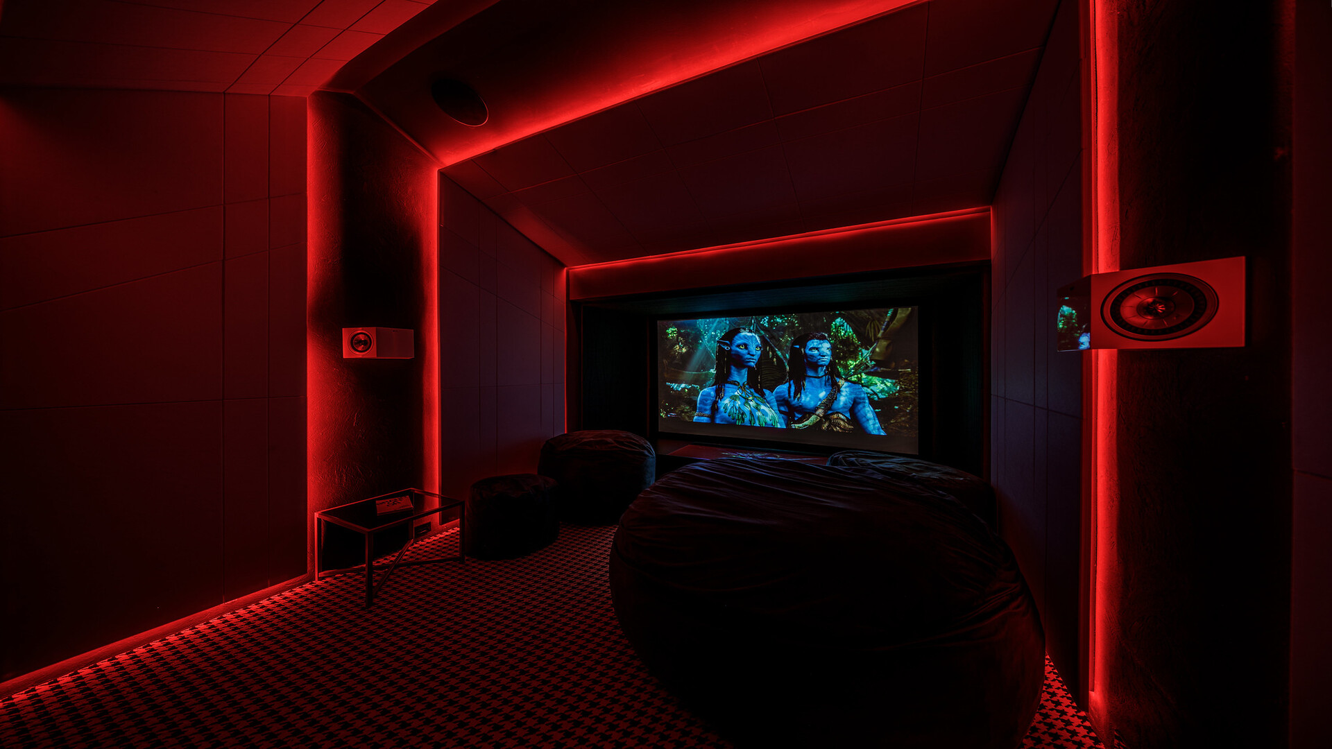 Revolucionando el Entretenimiento en el Hogar: El Futuro de la Automatización A/V". 5 Moderno teatro en casa con luces rojas y altavoces laterales de alta calidad.